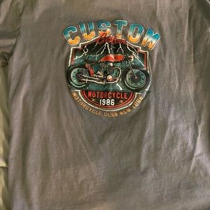 Mainly grey t-shirt with a motorcycle on it.